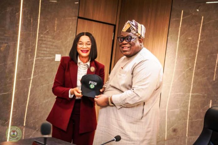 The Honorable Chairman Federal Civil Service Commission Prof Tunji Olaopa receiving a customized face cap from the Administrative CEO Public Service Institute of Nigeria Imeh Okon Esq.