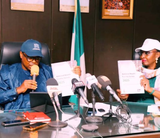 Honorable Minister of State for Health and Social Welfare Dr Iziaq Adekunle Salako and Permanent Secretary Federal Ministry of Health and Social Welfare,Daju Kachollom S. mni displaying the National Health Facility Survey Document launched at Ministerial Press briefing marking 2026 World Health Day.