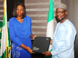 The leader of the delegation Ms Seun Ojo presents a proposed working document to the Honourable Minister. Dr. Bernard M Doro during the visit.