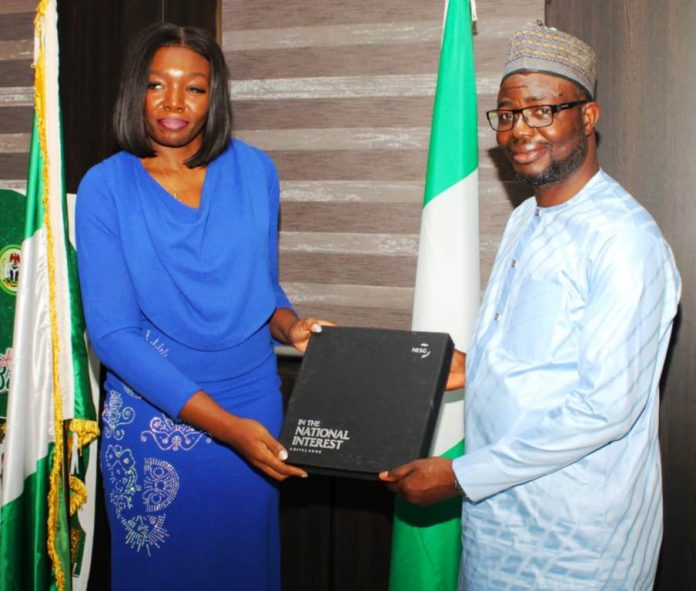 The leader of the delegation Ms Seun Ojo presents a proposed working document to the Honourable Minister. Dr. Bernard M Doro during the visit.
