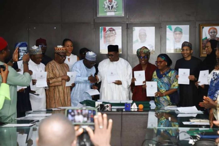 Professor Pate in handshake with the Registrar/CEO, Pharmacy Council of Nigeria, Pharm. Ibrahim Babashehu Ahmed FPSN during the launching of e-Pharmacy regulations, 2026; supported by other dignitaries at the event.