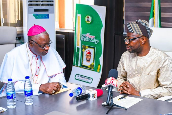 R-L: The honourable minister of Humanitarian Affairs and Poverty Reduction. Dr. Bernard M. Doro listened to Arch Bishop of Abuja, Archbishop Ignatius Ayau Kaigama when he paid him a courtesy visit in his office.