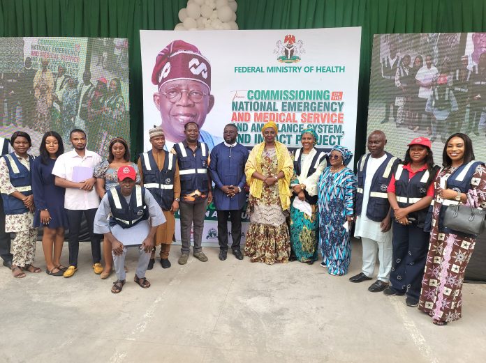 PHOTO -NEWS: The Permanent Secretary Federal Ministry of Health and Social Welfare, Daju Kachollom S. mni (C) flanked right and left by NEMSAS Desk officers at the Presidential Commissioning of Tricycle Ambulances.