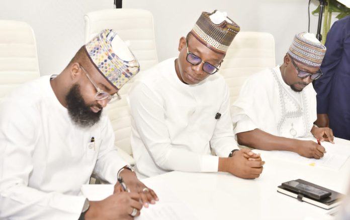 Director-General/CEO, Bureau of Public Procurement (BPP), Dr. Adebowale A. Adedokun, FCIPS (m) watches with keen interest while the Executive Vice Chairman/CEO, National Agency for Science and Engineering Infrastructure (NASENI), Mr. Khalil Suleiman Halilu and Managing Director/CEO, Rural Electrification Agency (REA), Mr. Abba Abubakar Aliyu sign the MoU in Abuja