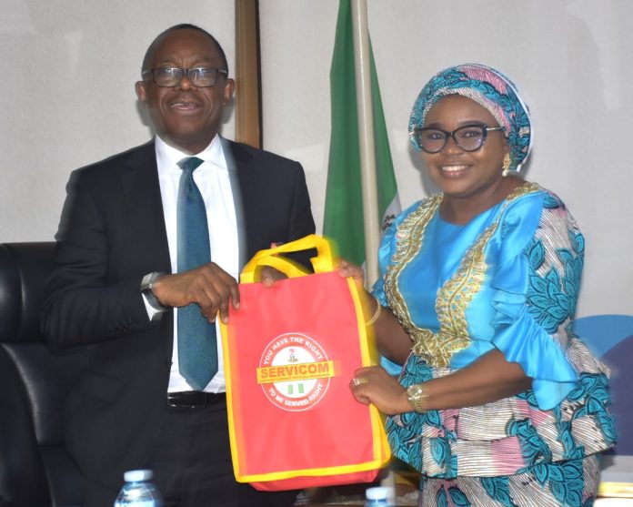 L-R The Managing Director and Chief Executive of the Nigeria Deposit Insurance Corporation (NDIC), Mr. Thompson Oludare Sunday receiving some awareness materials from the Ag. National Coordinator/CEO of the SERVICOM Office, Mrs. Helen Lawal during the courtesy visit to the Head Office of the NDIC on 7th July, 2026.