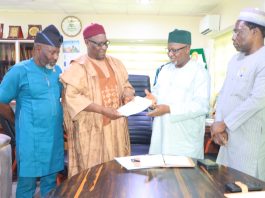 The Chairman of CORBON, Bldr. Samson Ameh Opaluwah (second left), presents a document to the President of COREN, Engr. Prof. Sadiq Zubair Abubakar, FNSE, FAEng, during the courtesy visit, as senior officials of both Councils look on.