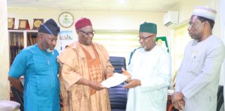 The Chairman of CORBON, Bldr. Samson Ameh Opaluwah (second left), presents a document to the President of COREN, Engr. Prof. Sadiq Zubair Abubakar, FNSE, FAEng, during the courtesy visit, as senior officials of both Councils look on.