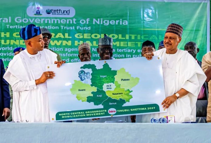 *2026 TETFUND NORTH CENTRAL ZONAL TOWN HALL MEETING* (L–R) Governor of Kogi State, His Excellency Ahmed Usman Ododo; former Governor of Kogi State, Captain Idris Wada; and Honourable Minister of Information and National Orientation, Mohammed Idris, fnipr, during the presentation of an endorsement card expressing the support of the North-Central geopolitical zone for President Bola Ahmed Tinubu and Vice President Kashim Shettima ahead of the 2027 general elections, at the 2026 TETFund North Central Zonal Town Hall Meeting on August 20, 2026, in Lokoja, Kogi State. Photo: Khalid Ahmed/FMINO