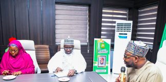 R:- The Honourable Minister of Humanitarian Affairs and Poverty Reduction. Dr. Bernard M Doro responds to the Registrar, Pharmacy Council of Nigeriaby his left in white, Pharmacist Ibrahim Baba Shehu Ahmed when the team from the council visited him in his office in Abuja.