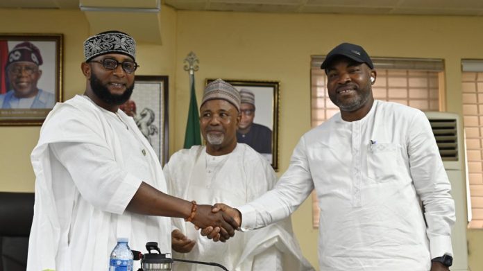 L-R: Outgoing RMAFC Secretary, Engr. Joseph Okechukwu Nwaze in a handshake with incoming RMAFC Secretary, Comrade Tosin Adeyanju as Federal Commissioner, as Kabir Mohammad Mashi Federal Commissioner, Katsina (Middle) watches on