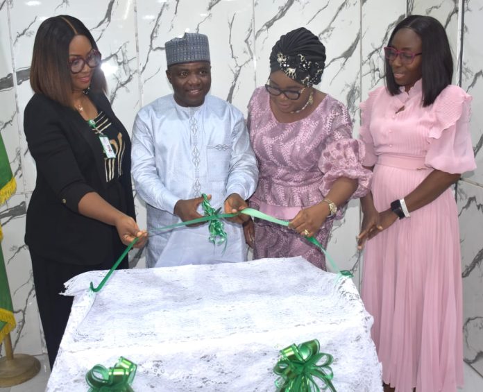 IMG-20260805-WA0041 L-R; The Executive Director Administration Sama’ila Abdu, being assisted by the Ag. National Coordinator/CEO of the SERVICOM Office, Mrs. Helen Lawal (3rd), Board Secretary Chinelo Nwosu (1st) and Team ‘C’ Leader, Mrs. Kikelomo Aina (4th) during the unveiling of the Nigeria Social Insurance Trust Fund (NSITF) Local Service Charter, at the Fund’s Headquarters in Abuja on Tuesday August 4, 2026.