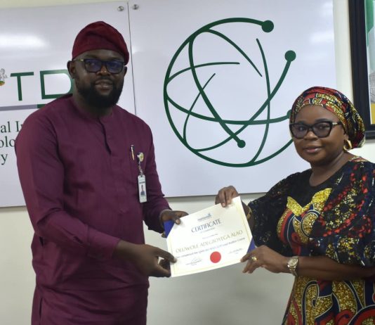 The Ag. National Coordinator/CEO of the SERVICOM Office, Mrs. Helen Lawal presenting ISO 9001 Lead Auditors Certificate to one of the successful members of staff, Oluwole Adegboyega Alao from the Corporate Communications and Media Relations Department during the Annual SERVICOM Parastatal Committee Workshop held on 24th August, 2026 at NITDA Headquarters in Abuja with the theme “Every Role Matters - Delivering Quality Service Together,”