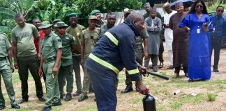 A Fireman demonstrates Fire Protocols to RMAFC Staff (Right): Director, Technical Services Department, Olaye Osayemen during the Fire Safety Training at RMAFC HQ 