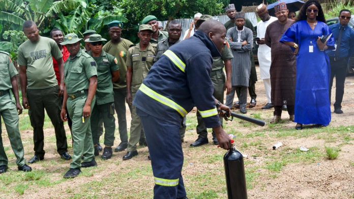 A Fireman demonstrates Fire Protocols to RMAFC Staff (Right): Director, Technical Services Department, Olaye Osayemen during the Fire Safety Training at RMAFC HQ 