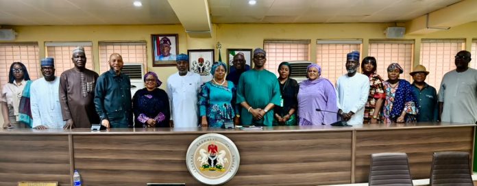 IMG-20260922-WA0021 Middle: Representative of the RMAFC Chairman, Dr. Ekene Enefe in a group picture with stakeholders during the meeting at RMAFC HQ, Abuja.
