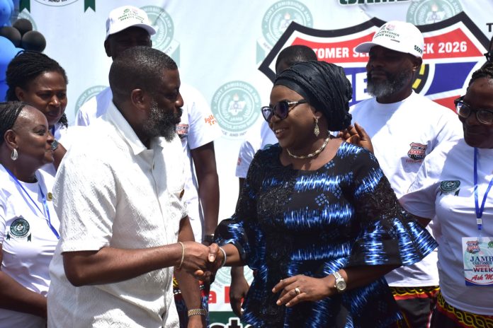 Ag. National Coordinator/CEO of the SERVICOM Office, Mrs. Helen Lawal in a ward handshake with the Registrar and Chief Executive of JAMB, Professor Segun Aina after his decoration as SERVICOM Champion during the Board’s commemoration of the 2026 Customer Service Week on 19th October, 2026 at the Headquarters of Joint Admissions and Matriculation Board (JAMB) in Abuja.