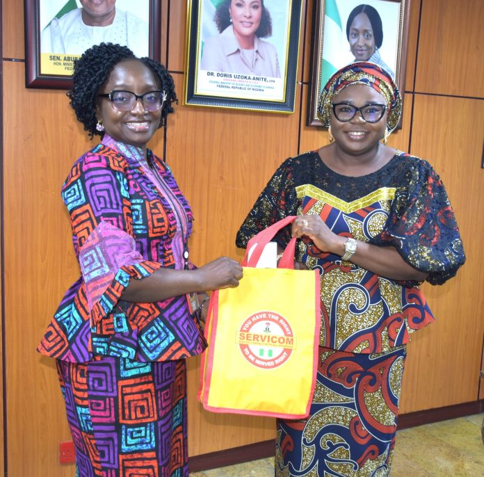 R – L; Ag. National Coordinator/CEO of the SERVICOM Office, Mrs. Helen Lawal presenting SERVICOM Awareness Materials to the Permanent Secretary Federal Ministry of Budget and Economic Planning, Mrs. Deborah Odoh after the latter was decorated as SERVICOM Champion during the official courtesy visit to the Ministry on 21st October, 2026 in Abuja.