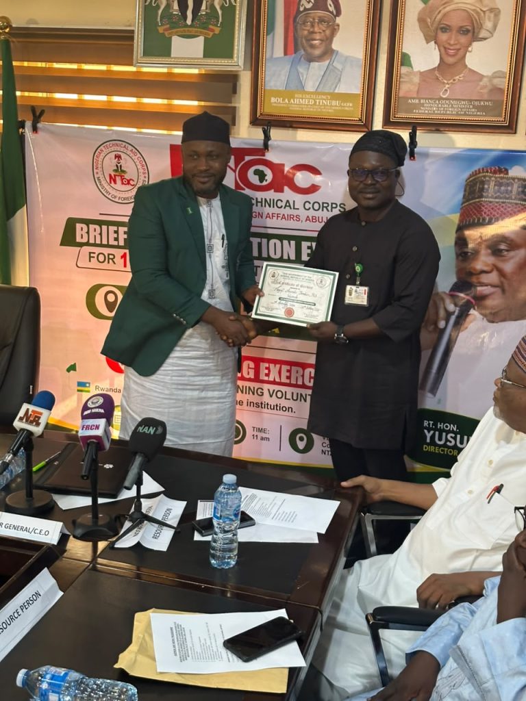 THE REPRESENTATIVE OF THE DG/CEO (NTAC) RT. HON. YUSUF BUBA YAKUB, MR. HAKEEM FALUSI OLADAPO, AD 1 PROGRAMS, PRESENTING  CERTIFICATES TO THE 10 RETURNING VOLUNTEERS FROM RWANDA.
 *26th OF OCTOBER 2026*