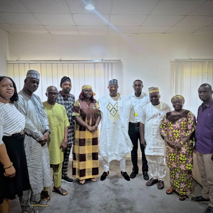 The Executive Director, NIWRMC, Dr. Abdulmumini Aminu Zaria (M), in a group phograph with the National Chairman, Nigeria Institute of Water Engineers, Engr. Temitope Aboyeji (L) and her team with the management staff of the Commission in Abuja.
